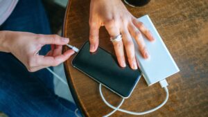 Woman charging her phone with a power bank while traveling
